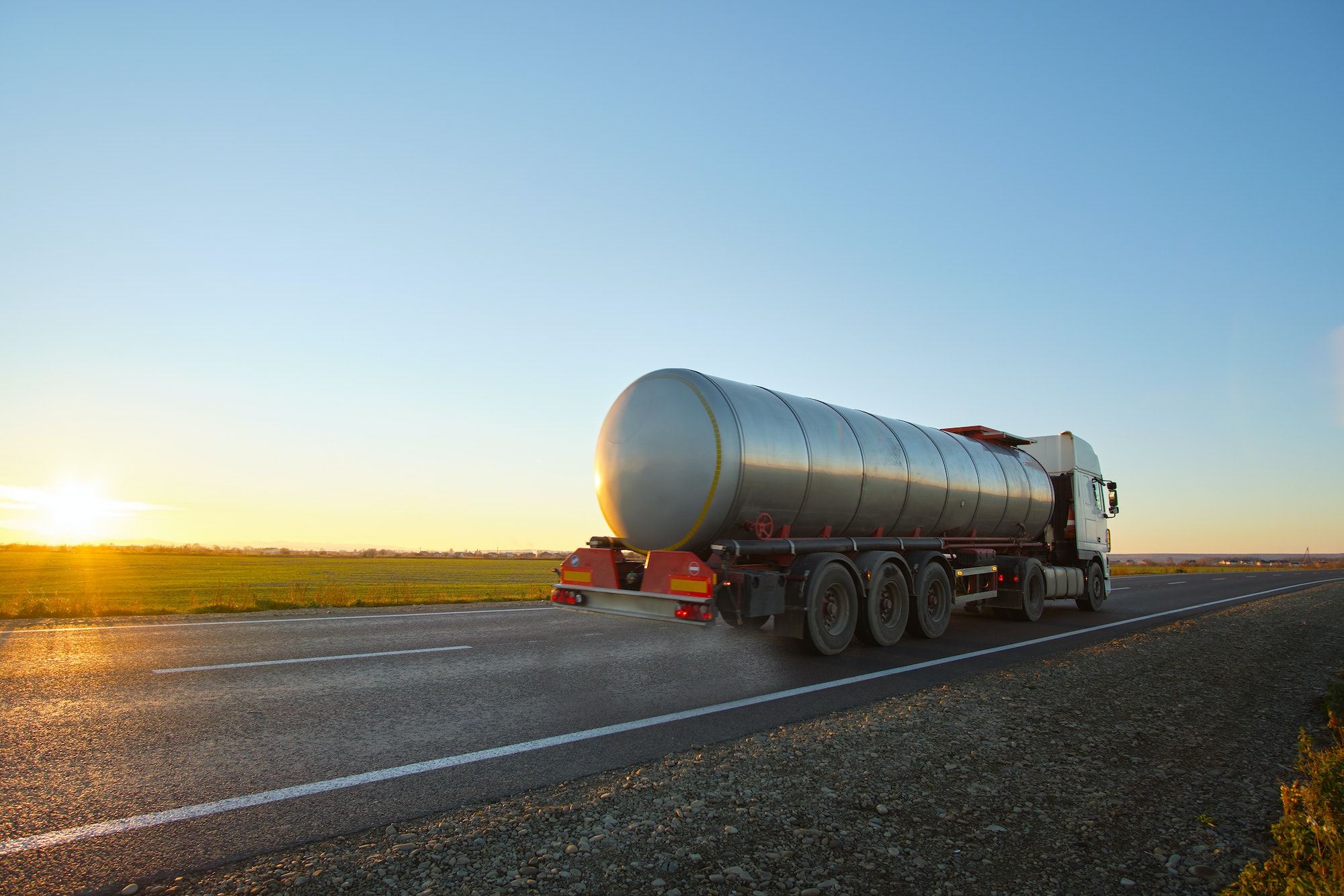 Petrol cargo truck driving on highway hauling oil products. Delivery transportation and logistics