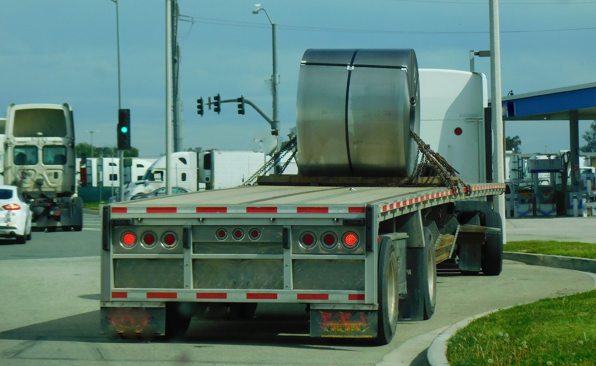 Transportation and Logistics! A large metal spool being hauled on a flat bed truck.