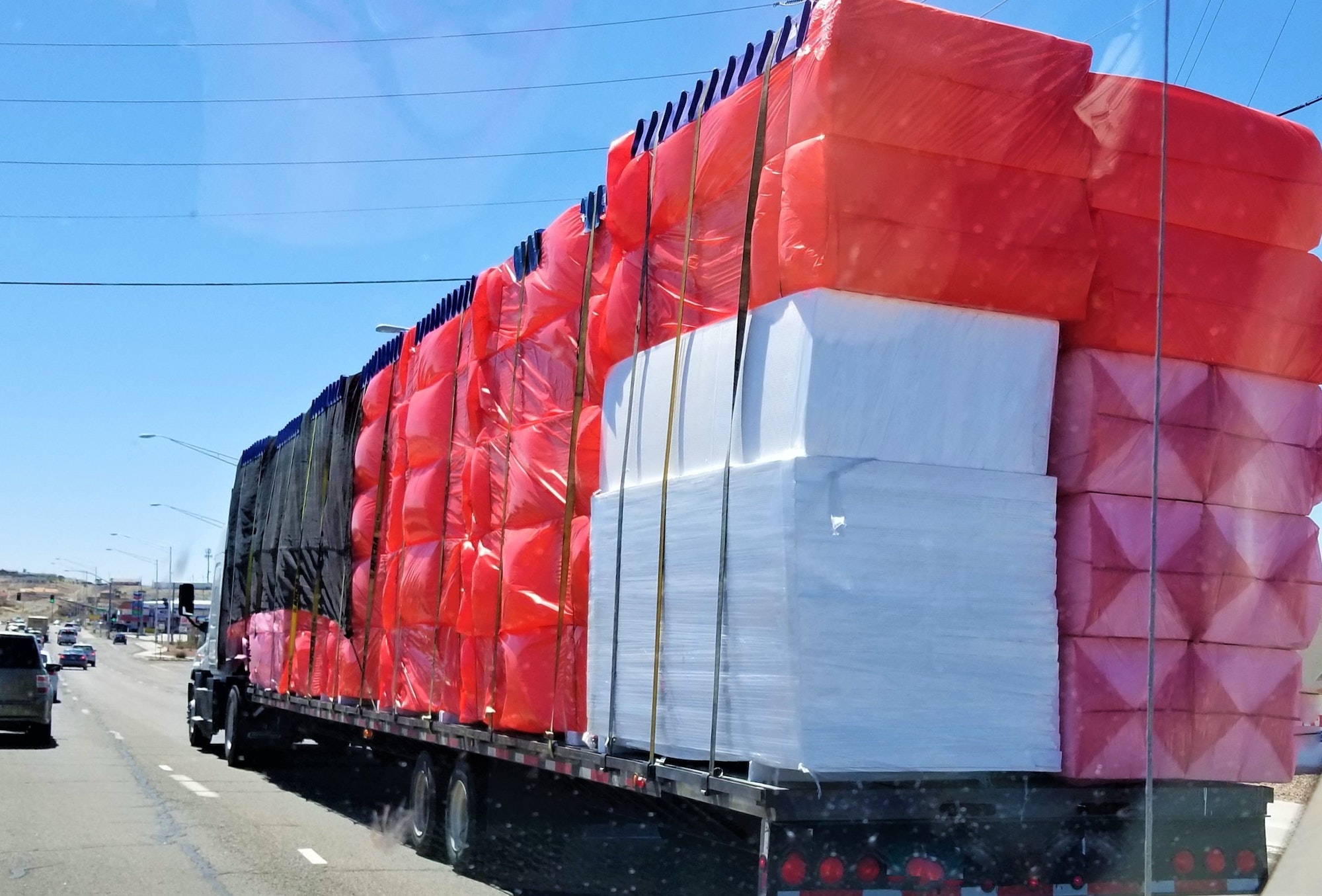 Big Rig Semi Truck Hauling a Flat Bed Filled with Plastic Covered Merchandise!