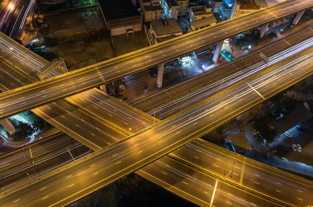 Expressways vs. Freeways: What's the Main Difference 1 top view of massive expressway at night with light of cars transportation industrial concept
