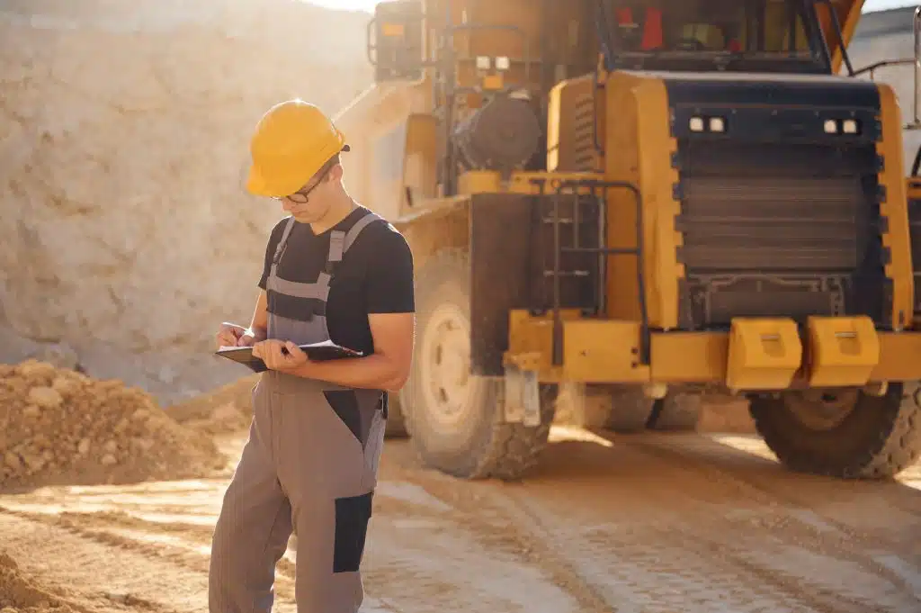 What is a Bill of Lading In Heavy Haul? 1 with documents near the haul truck man in uniform is working in the quarry at daytime